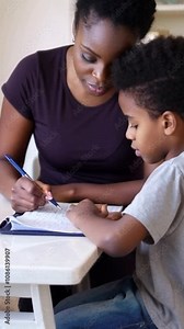 video of mother helping son with homework. african american family learning together at home. Stock Video