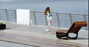 A young woman received messages from a loved one - she is happy. She reads the message again, presses the phone to her chest and beams with happiness.