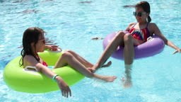 Kids having fun on innertubes in swimming pool