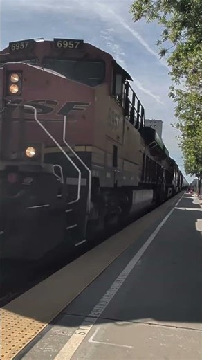 BNSF grain train the Amtrak train at station at Corcoran California