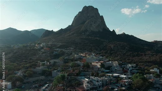 Peña de Bernal backward aerial reveals Bernal pueblo magico city center and Saint Sebastian's Temple