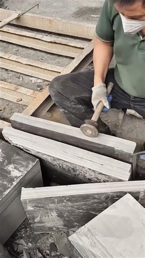 The process of splitting and carving large marble blocks into thinner slabs using manual hammer tool