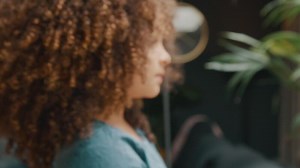 Girl standing in living room turning head looking into lens