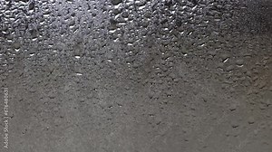 Splashes of water droplets on the glass. Window on a rainy day.Wet glass with large drops of water or rain. Video of water droplets on a clear glass surface during heavy rain. Dripping water