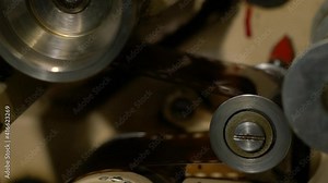 The film in the film projector mechanism slowly stops on the rollers Stock Video