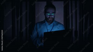 IT technician in data center working on laptop suddenly deactivating server room. Worried specialist typing code on keyboard turning on power cheering up laughing of failure.