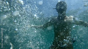 Man plays and makes bubble underwater. Freediver creates the bubble ring moving underwater