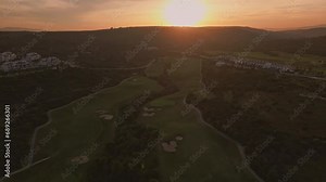 Establishing aerial panoramic view of a green golf course. Drone flying over golf club on a beautiful sunset Stock Video