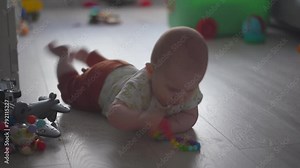Baby exploring all around the house, 7 month old baby boy crawling, touching everything. Baby learning to crawl and play on the floor with a toys.