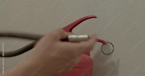 Red fire extinguisher, extinguishing systems. The hands of the fire safety instructor put the parts in place. Close up. Extinguishers need to have an internal examination conducted.