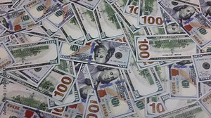 A stack of 100 US dollar bills moved slowly.