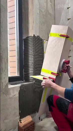 Installing large ceramic wall tiles with precision using suction tools and clips for even spacing