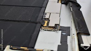 Close-up of tablet maintenance, showcasing technical care and precision in the repair process. Tablet repair close-up, showcasing tools and necessary care for an efficient maintenance process.