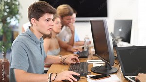 Engrossed in his work, student sits near computer, fully immersed in his studies. High quality 4k footage