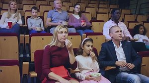 parents with children sitting at movie in cinema