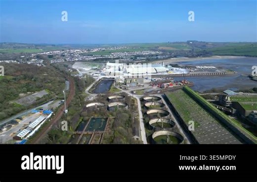 Par, Cornwall, England: DRONE VIEWS: Par Docks with the town of Par and Par Sands beach in the b/g; in the f/g is a disused sewage farm. The Docks is a milling centre and also receives a slurry form of china clay for transporting to nearby Fowey Stock Video Footage - Alamy