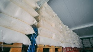 Storage with Large Bags of Flour ready for further Transportation and Shipment. Close Up of Flour Bags being stacked in Pallets in Industrial Warehouse