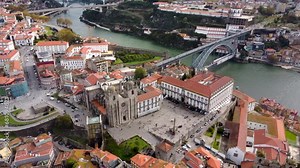 PORTO - Portugal. Cinematic aerial view of this historic medieval European city. View of Se do Porto Cathedral, Museu de Vitral and Dom Lusi I Bridge. Camera panning right in tilt town position.