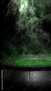 Vertical Witch Cauldron Smoking Green 4K Loop features a metal cauldron with green glowing smoke rising-up against a black background in a vertical ratio loop, not a.i.
