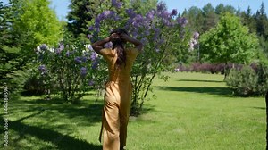 young beautiful woman in a summer garden in bloom, a slow walk, nature and the concept of happiness