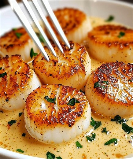 Pan-Seared Scallops in Creamy Garlic Butter Sauce 🧄🦪 Rich, elegant seafood dinner ready in minutes! 📝 Ingredients: 10 large sea scallops 2 tbsp butter 1 tbsp olive oil 3 cloves garlic, minced 1/2 cup heavy cream 1/4 cup chicken broth or white wine 1/4 cup grated Parmesan cheese 1 tbsp lemon juice Salt and pepper, to taste Fresh parsley, chopped (for garnish) 🍴 How to prepare it: 1️⃣ Prepare the scallops: Pat scallops completely dry with paper towels — this ensures that perfect golden sear an