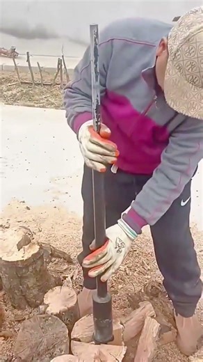 splitting thick wooden blocks into smaller logs using a heavy manual sliding log splitter for wood