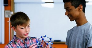 School students experimenting molecule model in laboratory at school