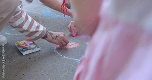 Hands drawing close up. Interactive and Participatory: Some drawings invite passersby to participate by filling in missing details or adding their own elements to the artwork. Collab artwork details.