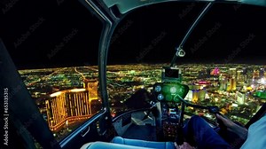 Helicopter cockpit flight on Las Vegas downtown with illuminated casino hotels at night. Scenic flight above Vegas skyline by night in the Nevada state of United States of America.