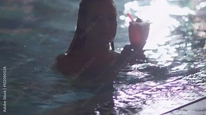 Young attractive woman gets out of the pool and drinks a cocktail in a spa wellness center. Shot on RED Cinema Camera.