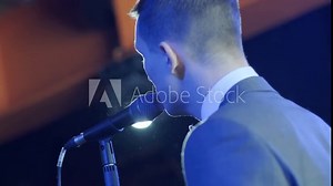 Man singing song in microphone during performance on stage on rock concert. Close up man rock star singer on music concert on colorful light background Stock Video