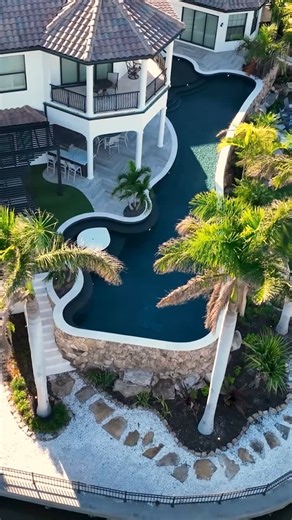 Lucas Lagoons on Instagram: "The challenge of this unique project was to elevate the new pool to make it more usable for the entire family. It is a disguised lap pool with a freeform shape that follows the minimum setbacks from the water, creatively making the pool as big as possible. It's backed with a blend of modern features and a timeless rock wall. #insanepools #lucaslagoons #pool #backyard"