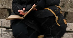 Travel woman with red hat in black jacket write on notebook, make notes, drawing some sketche against the river view, local travel, mental health.