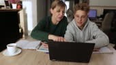 Mother and teenage boy doing some homework together. Mother is...