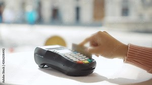 Woman swiping credit card on pos terminal close-up. Girl using credit card to pay for order in restaurant. Easy and fast transaction.