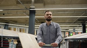A man pushing trolley with new laminate in hardware store