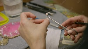 Dental specialist deals with the artificial tooth production at the laboratory. Using small stomatology tools for artificial tooth production. Finishing artificial tooth production. Dentistry material