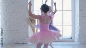 Young girls from ballet dancing ballet in white studio. Pretty graceful ballerinas doing elements of classical ballet - arts concept 4k footage