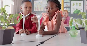 Conducting science experiment with wind turbine model, children in school classroom. Kids, learning, education, wind energy, renewable, students