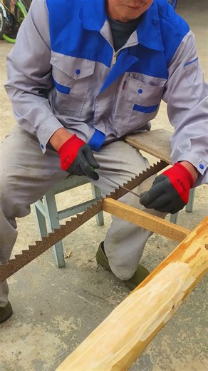 The old man sharpened the large saw using traditional hand tools.