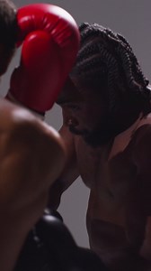 Vertical Video Close Up Studio Shot Of Two Male Boxers Wearing Gloves Fighting In Boxing Match | Free Stock Video Footage