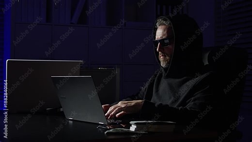 Hacker typing code in laptop at night office. Hacker theft. Cyber hacker typing dangerous code. Night hacker typing code on computer. Hackers risk.