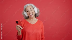 Happy woman dancing and listening to music with a mobile