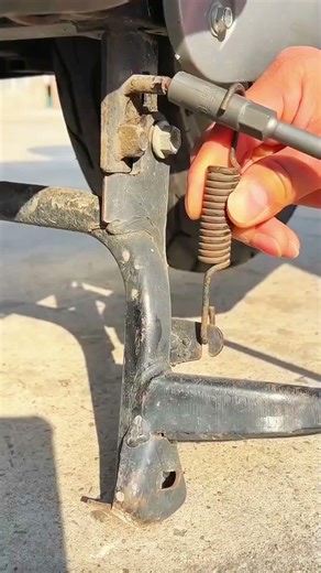 Spring-loaded stand—rust and steel balance stability.