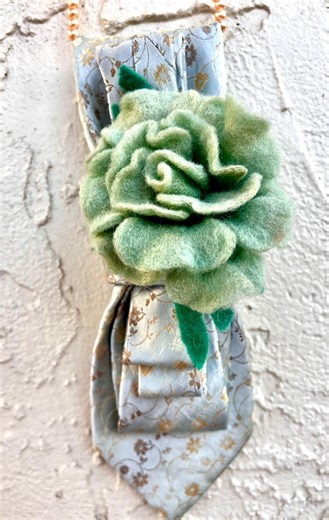 Silk necktie with wool brooch