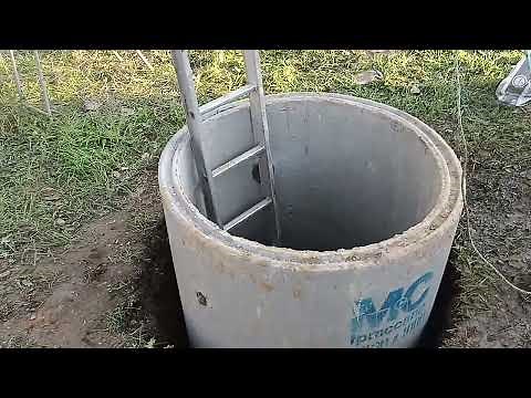 Hand digging a well for water in the UK with concrete drainage rings. Off grid water.