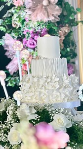 @iamowning @axlroseu Introducing our stunning all-white three-tier wedding cake! The elegantly ruffled bottom tier adds a touch of whimsy, while the delicate rice paper center detail brings an artistic flair. The top tier features a smooth finish, but the real showstopper is our adorable furbaby, handcrafted from fondant, peeking out to add a playful charm. 🐾 Coordination @thecenterpiece styling @hansberdejo venue @chateaudebusaycebu #weddingcakecebu #cebuweddingcake #weddingsincebu #cebucake #