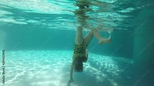 Girl doing an underwater handstand in the pool