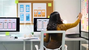 Female ui ux designer working on mobile app design prototype. Ui/ux designer is analyzing the user flow of a mobile application prototype she is designing, using sticky notes on a whiteboard. Stock Video