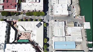 Fisherman's wharf aerial birds eye view to pan up of Aquatic Park with the Golden Gate Bridge in the background, San Francisco